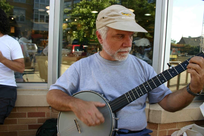 a man playing a small size guitar outdoors