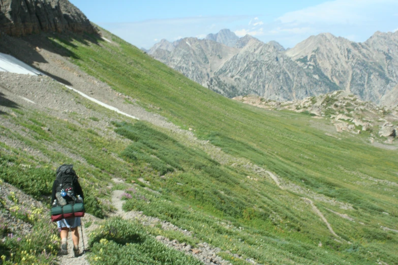 a woman with a backpack hiking on a steep slope