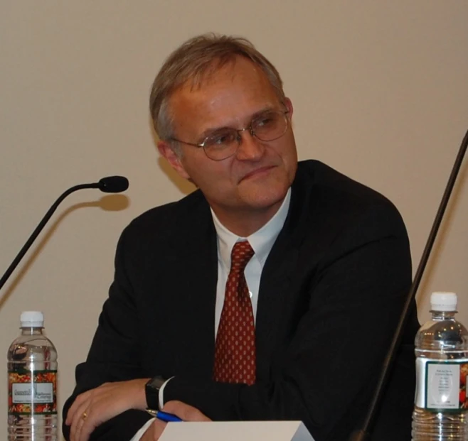 a man sitting at a desk with a pen and paper