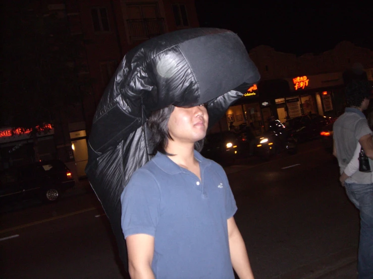 the man is wearing a black umbrella in his head