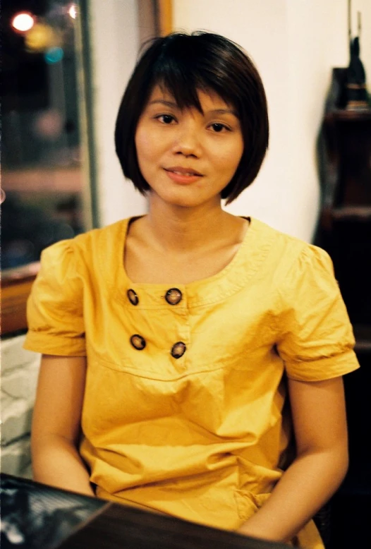 a woman sitting in front of a brown clock