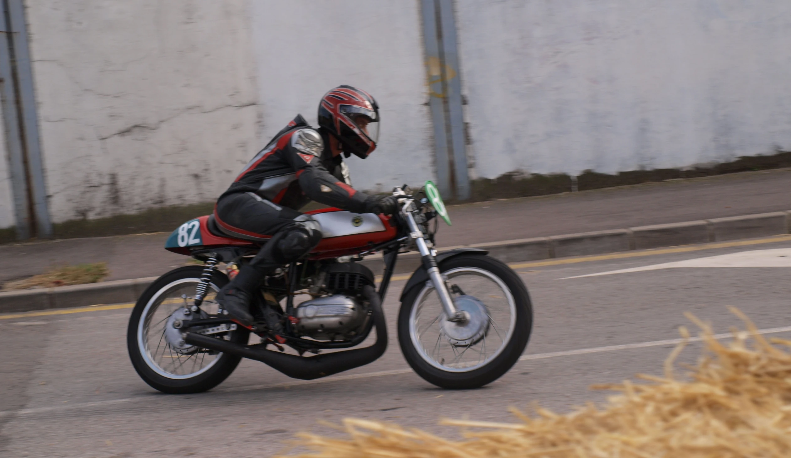 person wearing all black riding on a red and white motorcycle