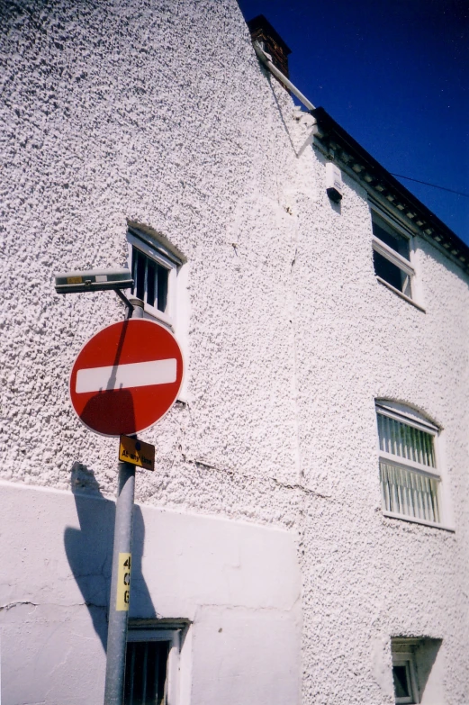 a red round street sign sitting on the side of a building