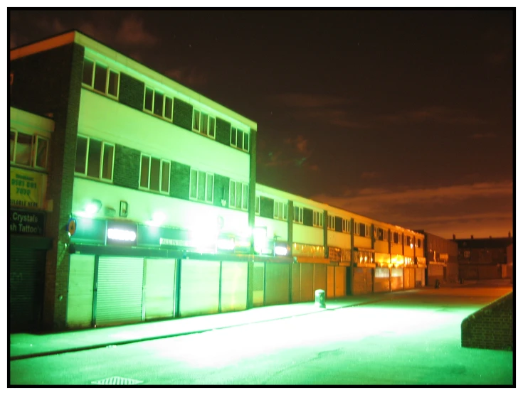 an outside view of a business building lit up with the neon green lights