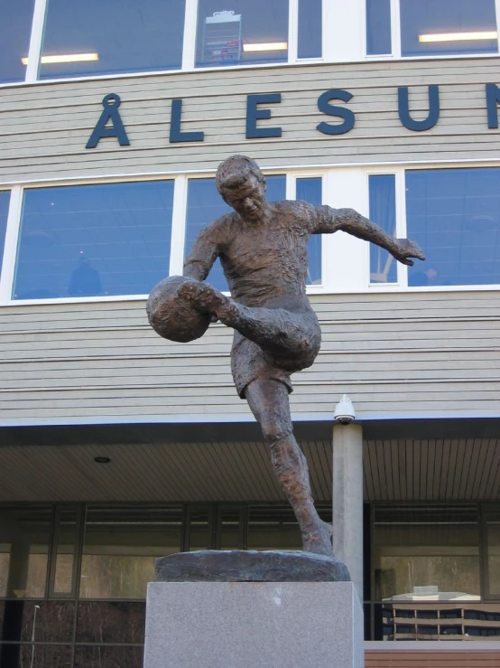 a statue of a male football player in front of a building