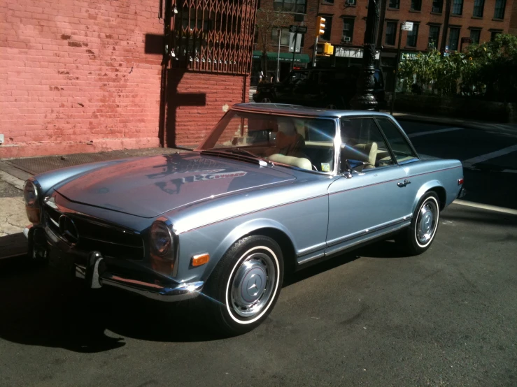 an old mustang sits parked on the side of the road