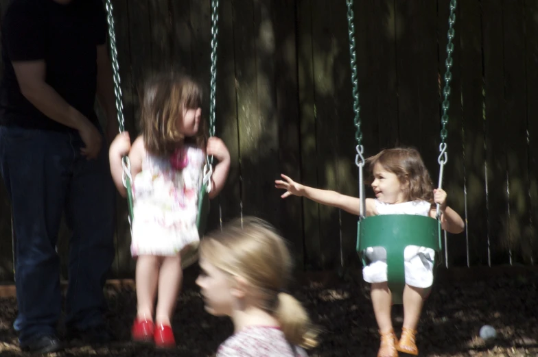 three s are on swings while one is pointing