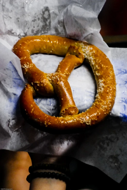 a person holding onto a pretzel in a napkin