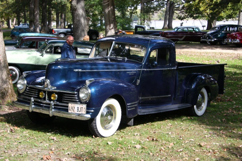 an antique blue car is parked in a field