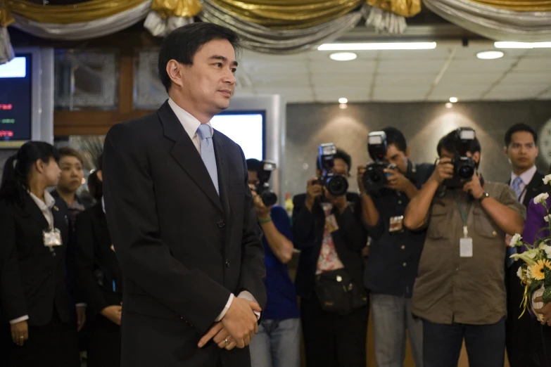 a man holding some flowers while wearing a suit and tie