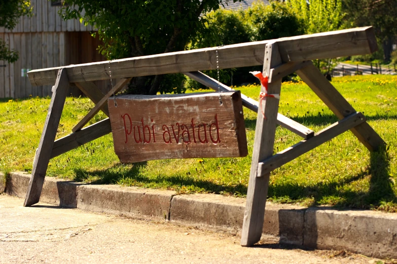 a wooden structure with graffiti on it and some grass