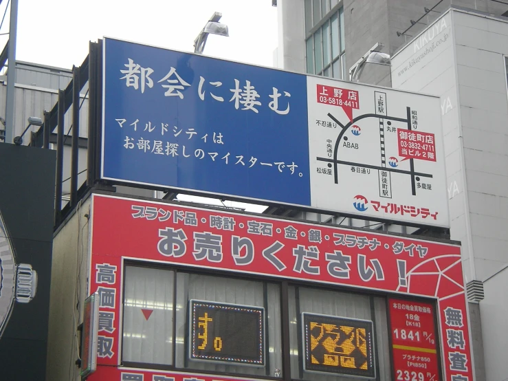 signs attached to the side of an apartment building in tokyo