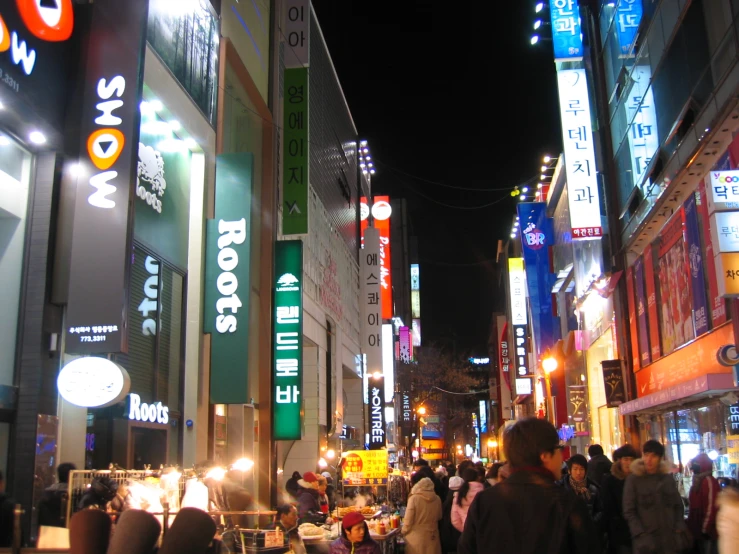 a street is crowded with people at night