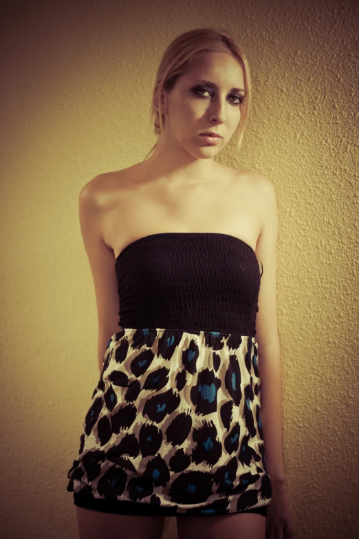 a young lady in a black top and leopard print short skirt