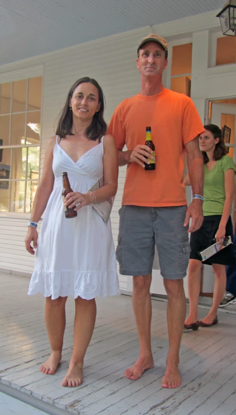 a couple in sun suits are standing on a wooden floor