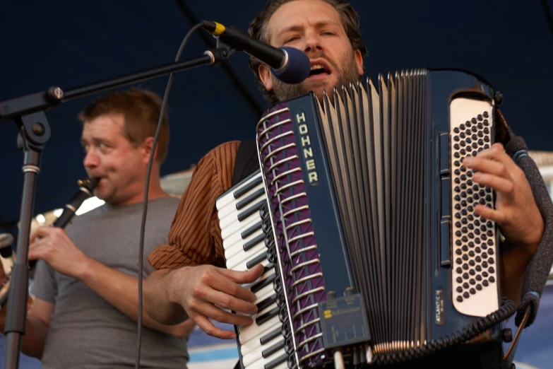 man playing a accordion at an outdoor festival