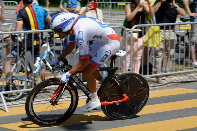 a bicyclist riding past spectators and onlookers