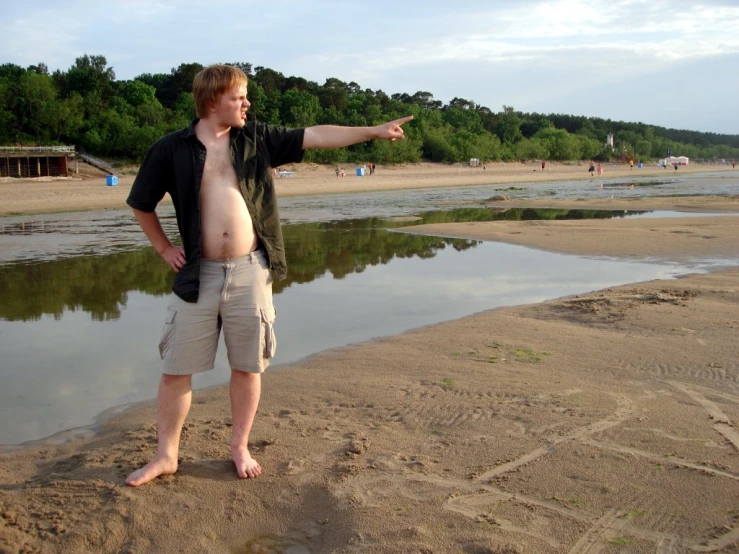 a man is posing on the sand at a beach