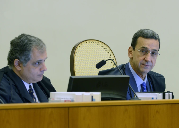 two men sitting in front of computers during a meeting