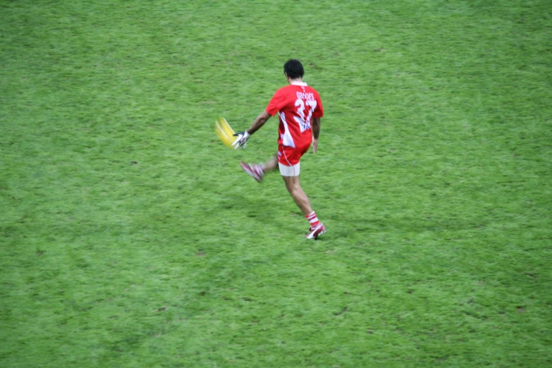 a man in red jersey and yellow and white glove holding a frisbee