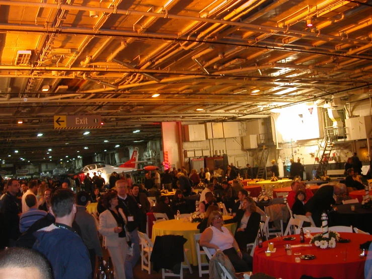 a group of people sitting around tables and chairs under a building