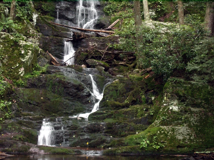 there is a man riding a horse near a waterfall