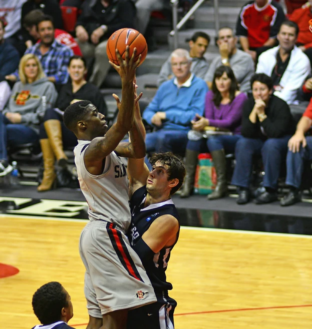 a couple of men in action playing a game of basketball