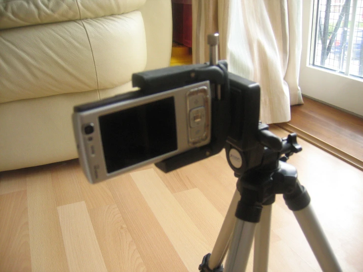 a phone is mounted on a tripod near a window