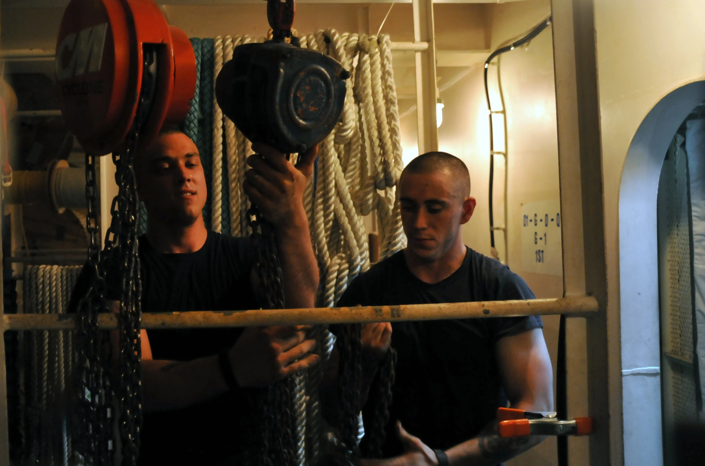 two men are on a rope pulling soing through a room