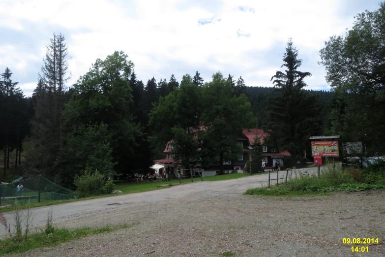 a gravel road lined with buildings and trees