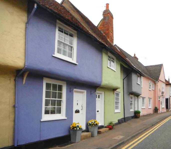 three identical houses in different colors are painted