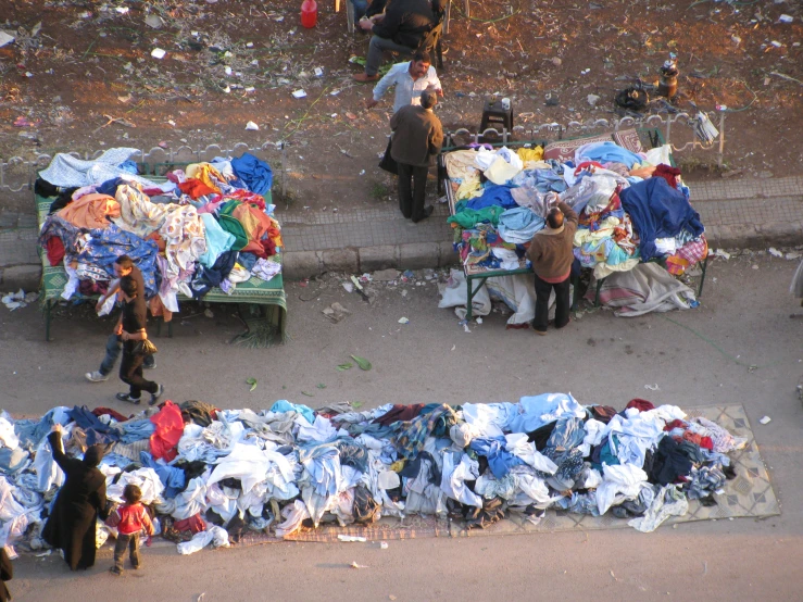 clothes are stacked on the street side and on the sidewalk