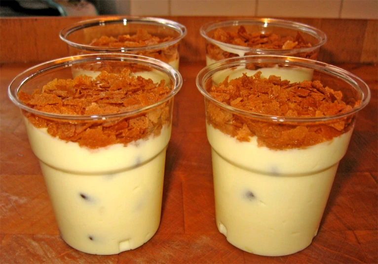 three desserts sitting in cup holders, one topped with cream