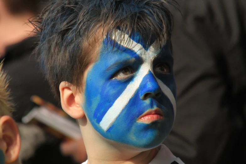 a boy with his face painted blue and white