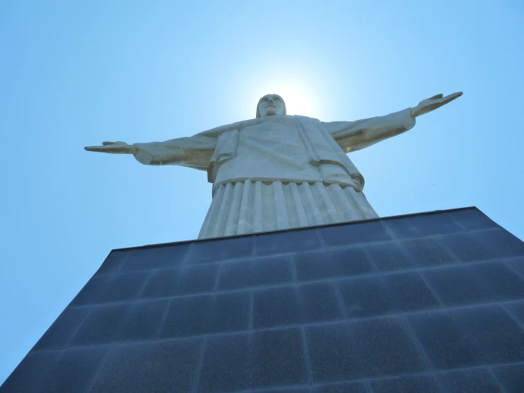 a large statue of the christ standing above a city
