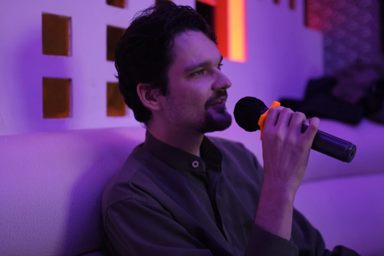 a man with a black hair holding a microphone