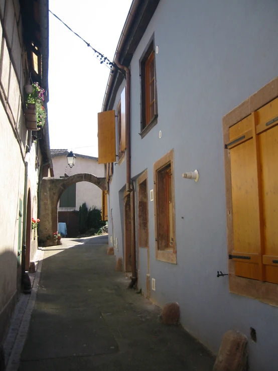 a narrow street has houses and windows in the street