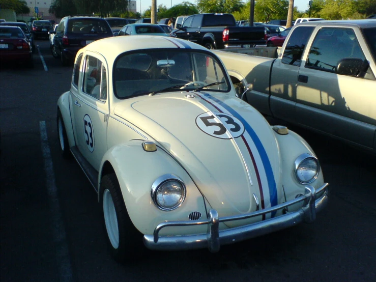 an old style bug sits in the middle of a parking lot