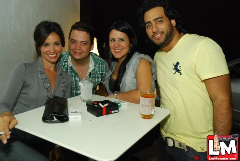 three people smiling while sitting at a table