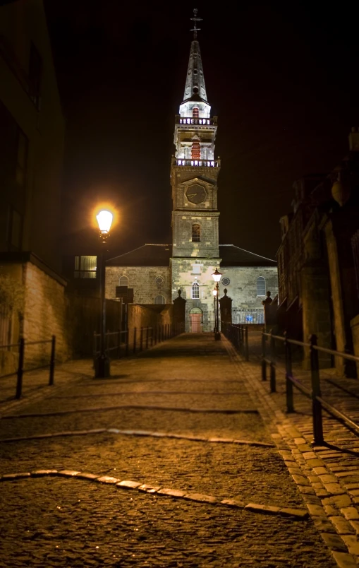 the old stone building has a steeple at night