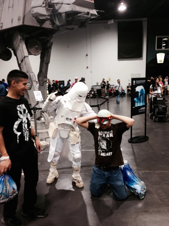 two men standing next to each other near a star wars robot