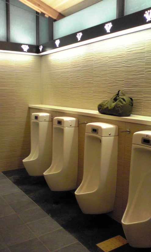 several urinals lined up in the middle of a public restroom