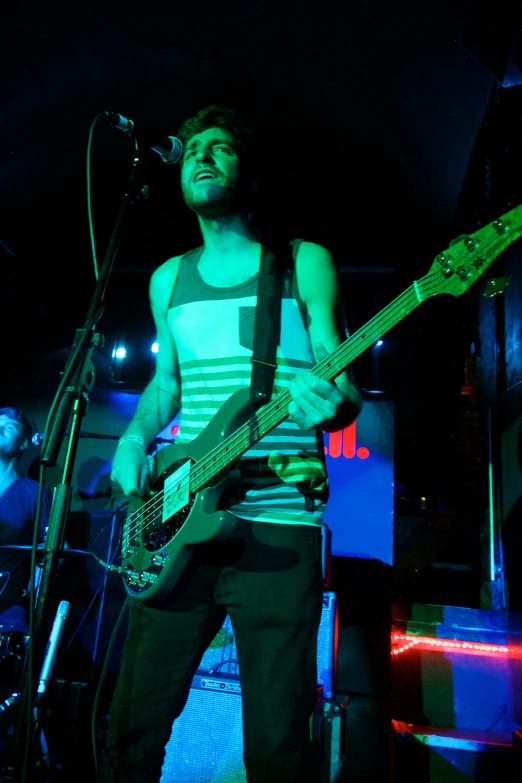 a young man playing guitar on a stage