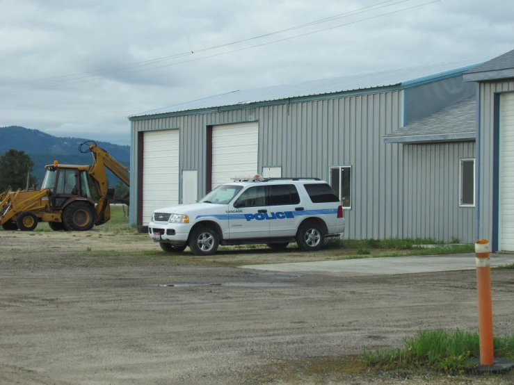 a white police van is parked outside of a building