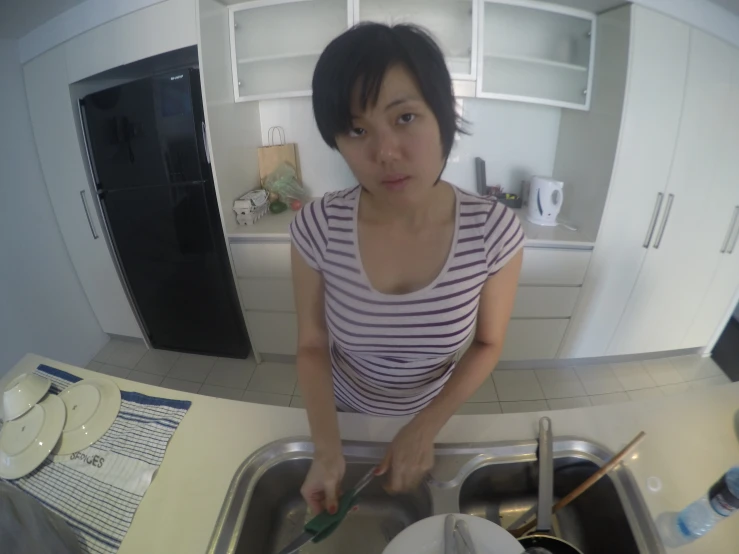 the woman is standing in the kitchen preparing food