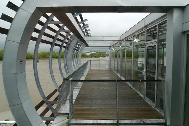 a walkway with steel rails and glass doors leading to the top