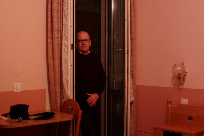 a man standing inside a doorway of a room
