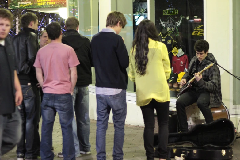 a group of people standing around on a sidewalk