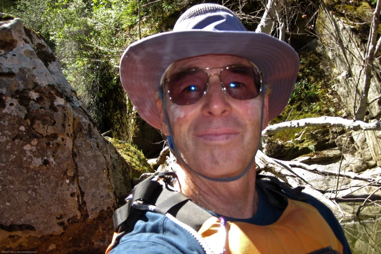 a man wearing sunglasses and a hat with a backpack on