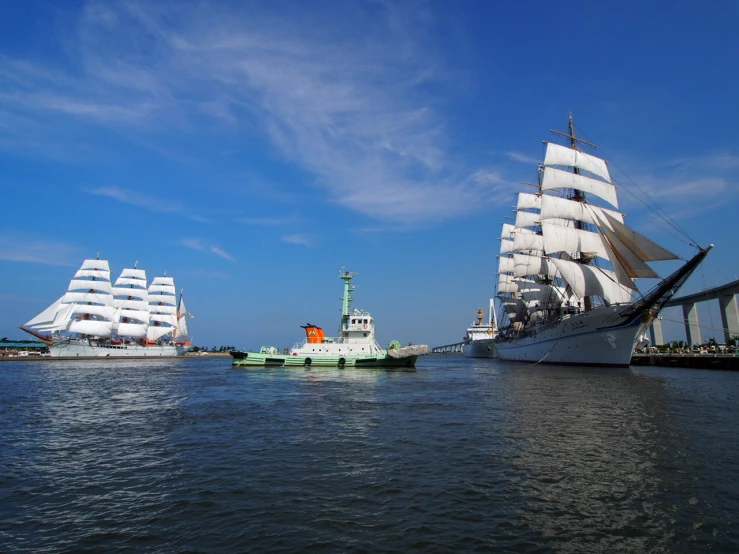 three large boats are sailing in the water